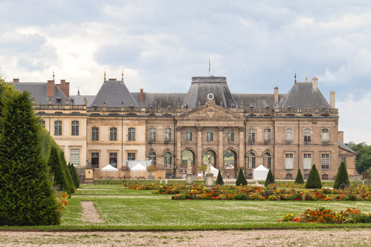 Photo du Château de Lunéville prise une journée nuageuse depuis le parc à l'arrière du château.